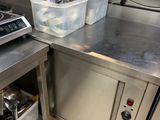 plan de travail en acier inoxydable dans une cuisine commerciale avec des casseroles et des poêles dessus