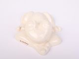 a small white figurine of a dog on a white surface