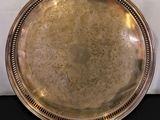 a silver plate with a spoon and spoon rest on a table