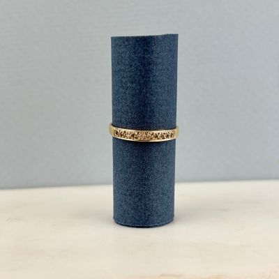 un cylindre bleu surmonté d'une bande dorée