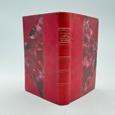 un livre rouge ouvert sur une surface blanche
