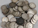 pile of silver coins on a white surface with a coin in the middle