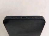 the back of a black cell phone sitting on top of a white table