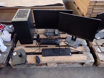 trois écrans d'ordinateur et un clavier posés sur une palette