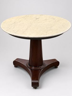une table à plateau en marbre posée sur un piédestal avec un socle en bois