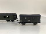 two toy trains sitting side by side on a white surface