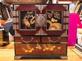 un petit meuble en bois surmonté de deux tiroirs