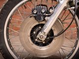 a close up of a motorcycle wheel with a brick wall in the background