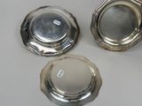 three silverplated dishes are sitting on a white surface