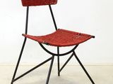 a red chair with a basket on the back of it
