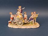 a figurine of a group of people riding a horse drawn carriage
