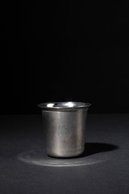 a silver cup sitting on top of a black table