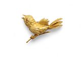 une image représentant une broche en forme d'oiseau doré sur fond blanc