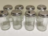 six glass salt and pepper shakers lined up on a table