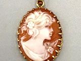 un pendentif plaqué or représente le profil d'une femme