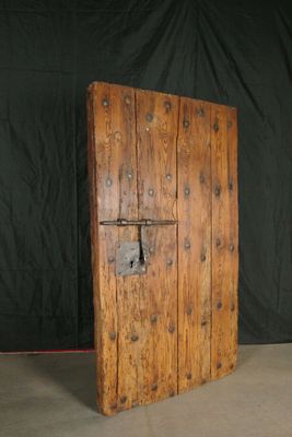 une vieille porte en bois avec un cadenas sur fond noir