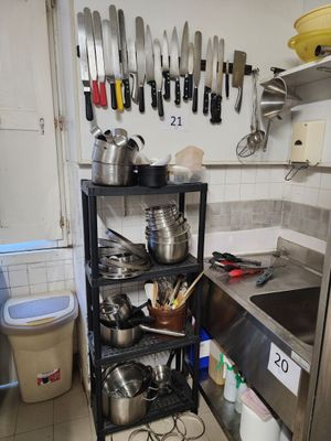 pots and pans on a shelf in a kitchen with a sink