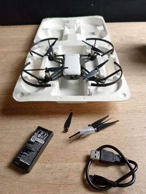 un plateau sur lequel se trouvent une télécommande et un petit drone