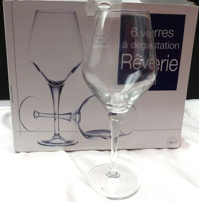 un verre à vin posé devant une boîte sur une table