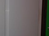 a white refrigerator in the corner of a room