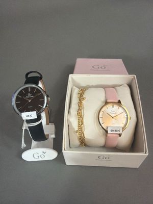 deux montres et un bracelet dans une boîte posée sur une table