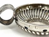 a silver bowl with a spoon in it on a white surface