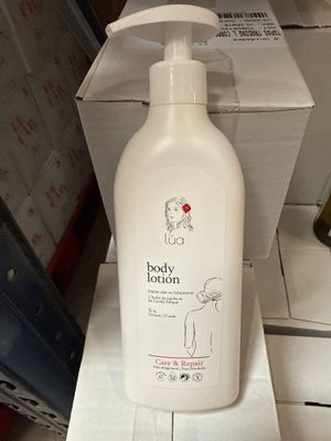un flacon de lait corporel posé sur une boîte