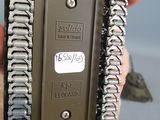 a person holding a metal device with a chain around it