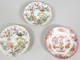 three plates with floral designs on them sitting on a table
