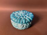 a small blue box sitting on a brown surface