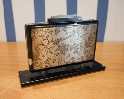 un sac à main argenté et noir posé sur une table en bois