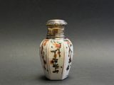 a small white vase with a floral design on it