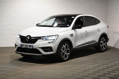 La voiture blanche est garée dans une pièce blanche au sol à carreaux.