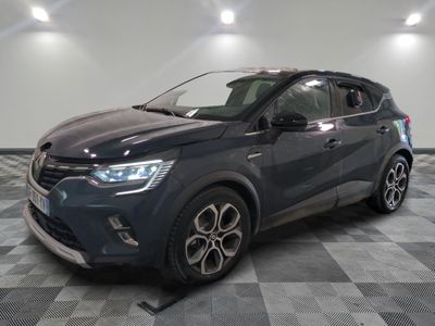 une voiture grise est garée dans une grande pièce au sol en damier