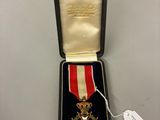 un gros plan d'une personne tenant une médaille dans un écrin