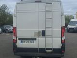 a white van parked in a parking lot with a ladder on the back of the van