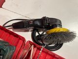 a red box that has a brush and a cord in it