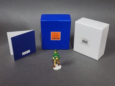 une petite figurine représentant un homme debout à côté d'une cabine téléphonique bleue