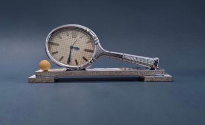 une horloge et une balle de tennis posées sur un socle en bois
