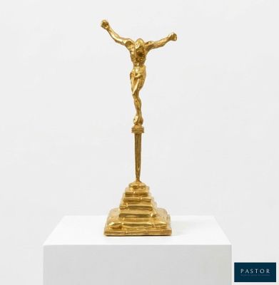 a gold statue of jesus on a pedestal with a white background