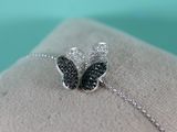 silver and black diamond butterfly bracelet on display on a white pillow