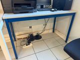 a desk with two computers and a printer on it