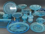 a lot of blue glass dishes and plates on the table