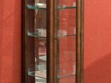 une vitrine en bois avec des portes vitrées, située sur le côté d'un immeuble