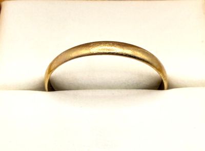 a gold ring sitting in a white box on a table