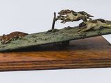 sculpture en bronze représentant un cheval et un chien, posée sur un socle en bois