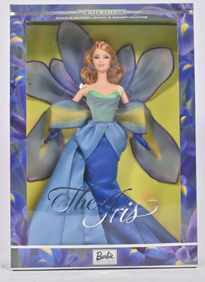La poupée porte une robe bleue ornée d'un papillon.
