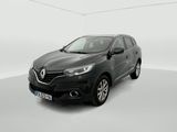 Une voiture noire est garée dans une pièce blanche