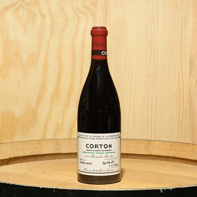 a bottle of wine sitting on top of a barrel
