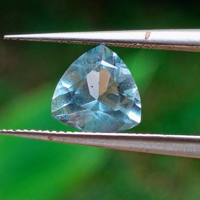 une topaze bleue tenue par une pince